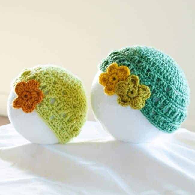 yellow and green lace crochet baby hats with decorative flowers attached