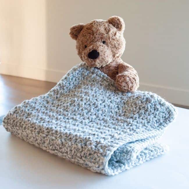 teddy bear holding crochet baby blanket