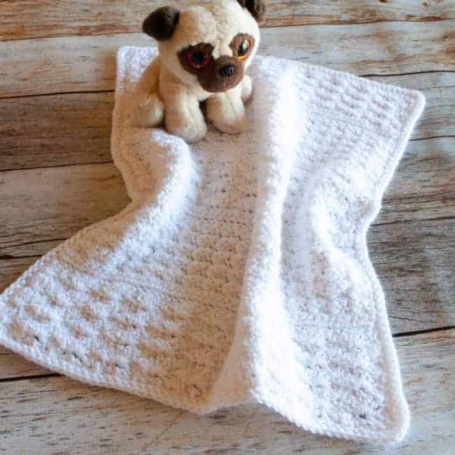 white preemie crochet blanket with stuffed dog toy