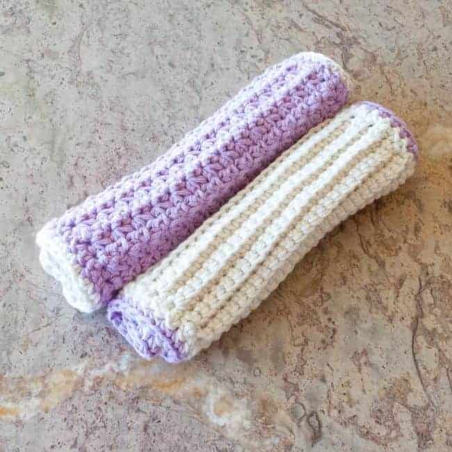 two crochet washcloths purple and white