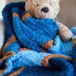 teddy bear and blue crochet baby blanket