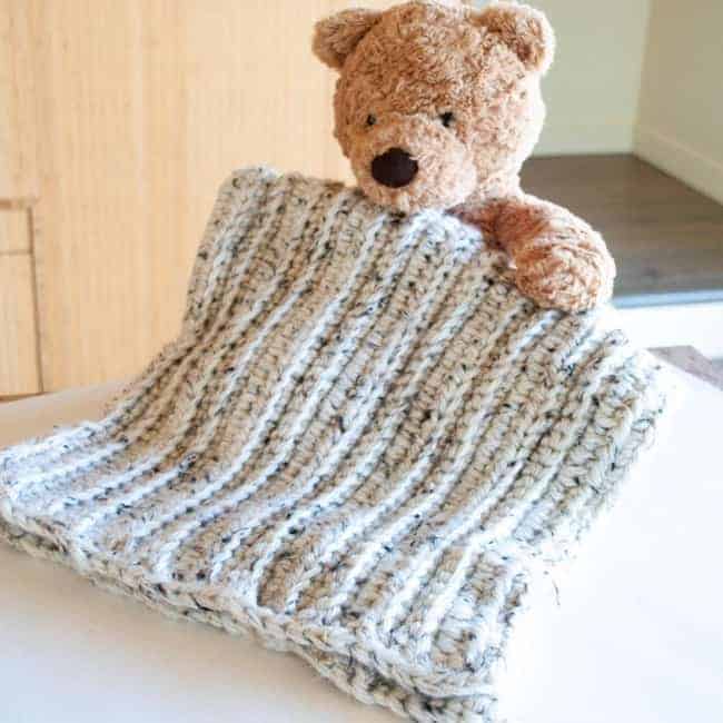 teddy bear holding crochet baby blanket with ridges