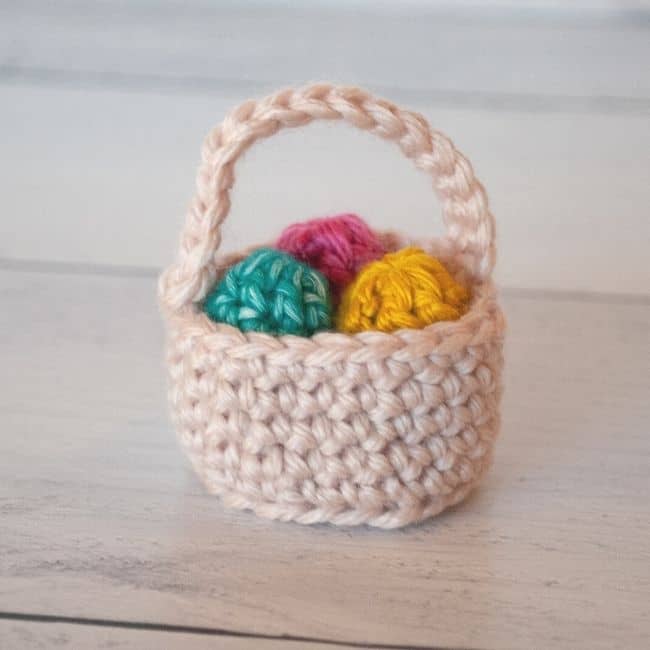 mini crochet easter basket holding three mini crochet easter eggs