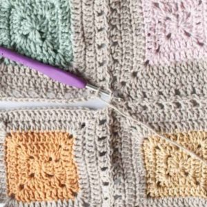 close up of four solid granny squares being joined using a continuous join as you go method