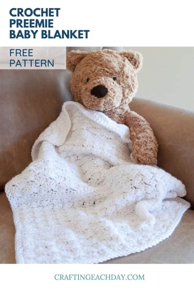 teddy bear wrapped in small white crochet blanket with text reading crochet preemie baby blanket free pattern
