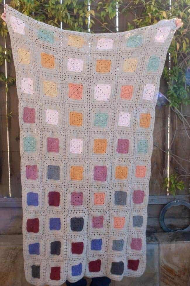 scrap yarn crochet blanket being held up
