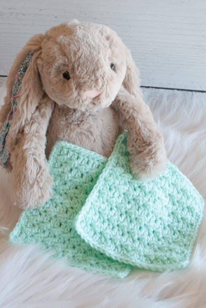bunny holding two green crochet bonding squares