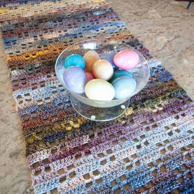 slightly diagonal view of crochet table runner with a bowl of eggs on it