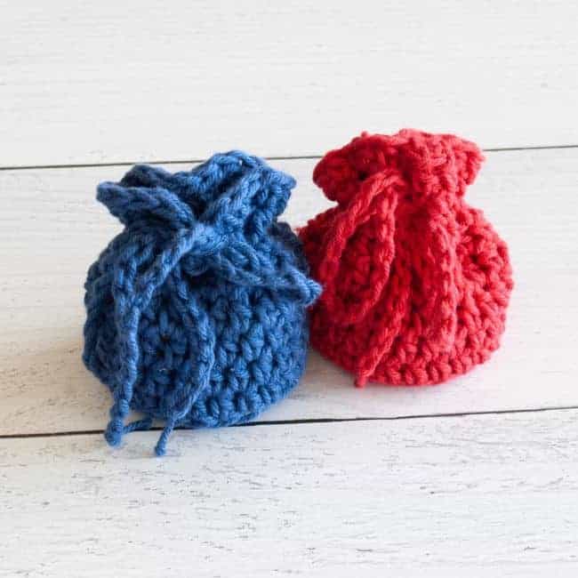 two drawstring crochet dice bags tied closed