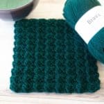green sedge stitch square, yarn, and part of a bowl