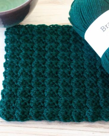 green sedge stitch square, yarn, and part of a bowl