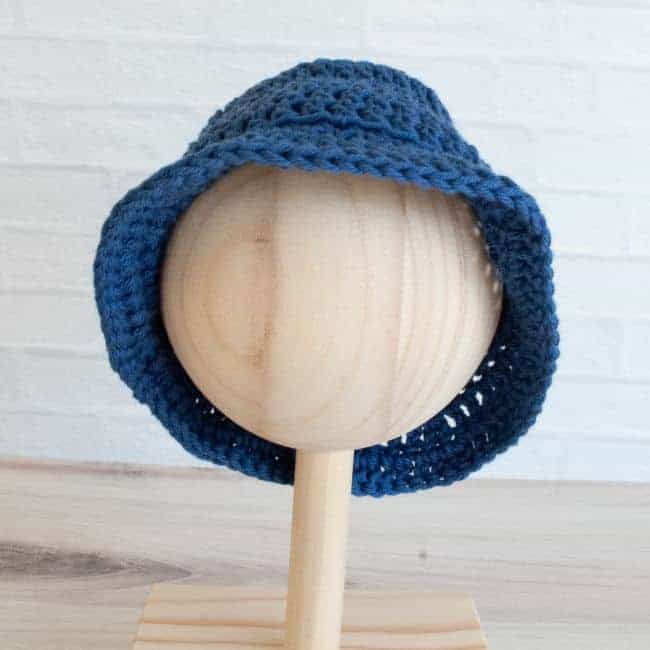 baby size blue crochet bucket hat on a wooden mannequin