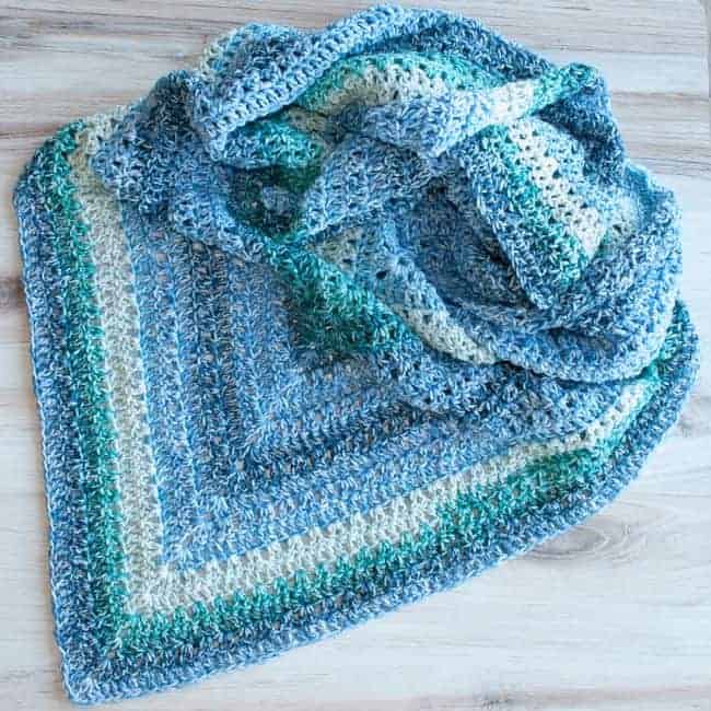 triangle crochet shawl laying on a flat surface