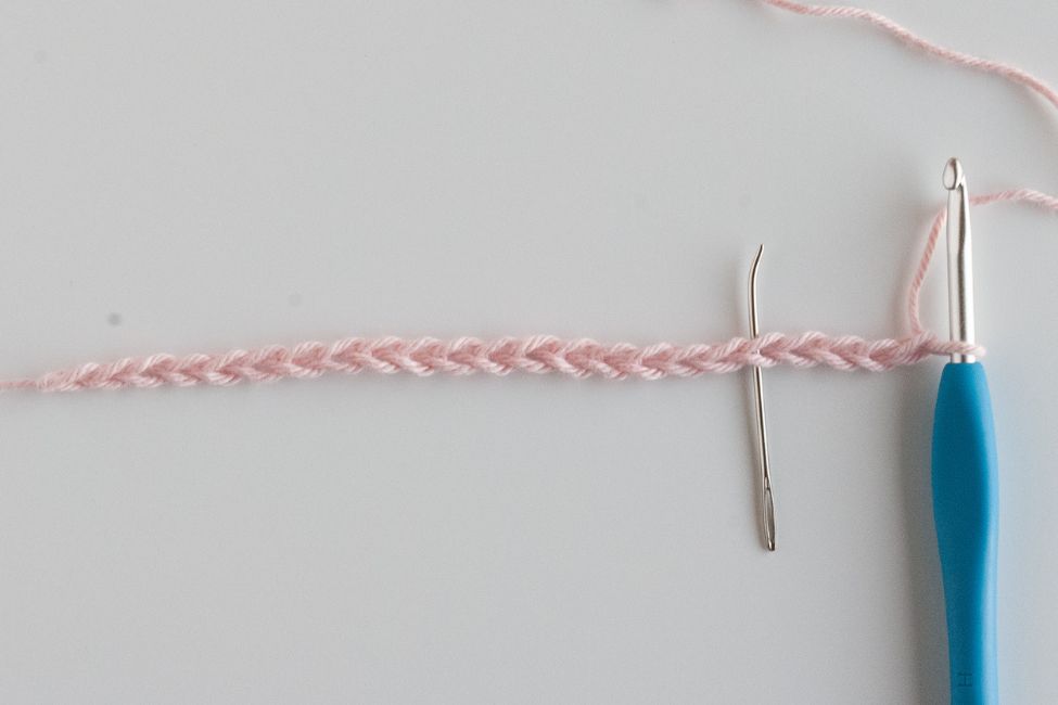 beginning chain with hook and needle marking a stitch