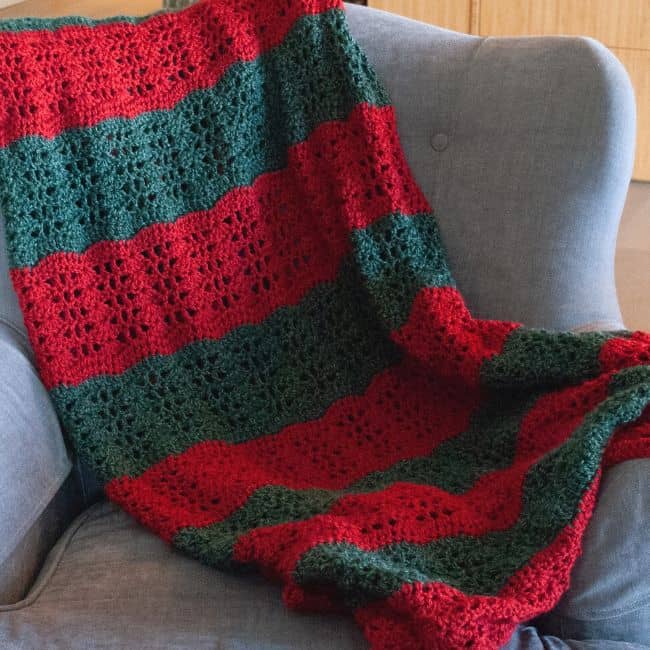 crochet christmas blanket draped on a chair