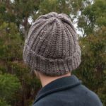 man wearing brown crochet beanie from the back